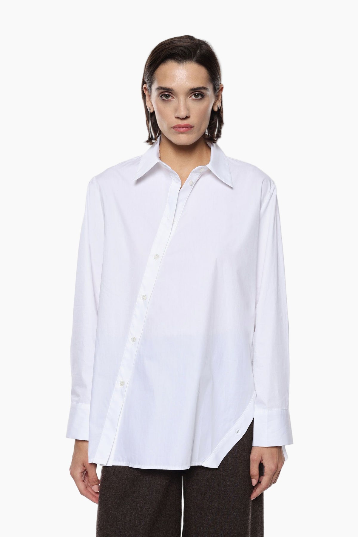 Woman wearing aThis loose-fit shirt features an asymmetric back design highlighted by a distinctive diagonal button closure. A classic collar and long sleeves with cuffs frame a contemporary silhouette.