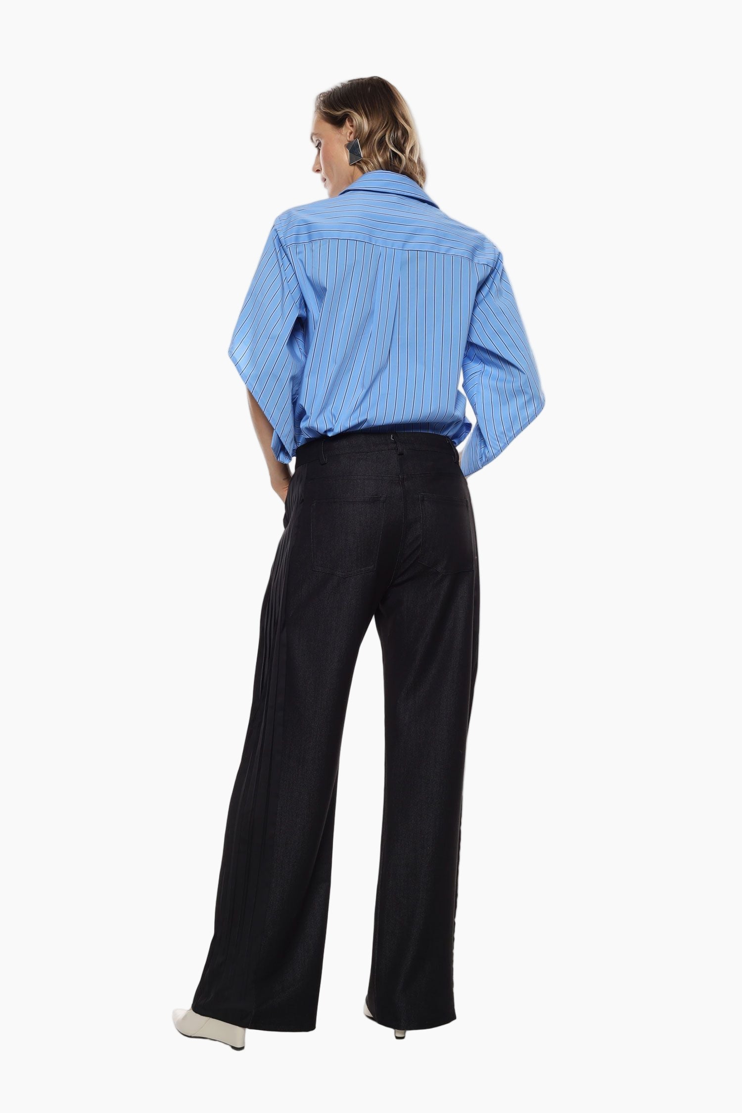 Person wearing a blue striped shirt and black pants