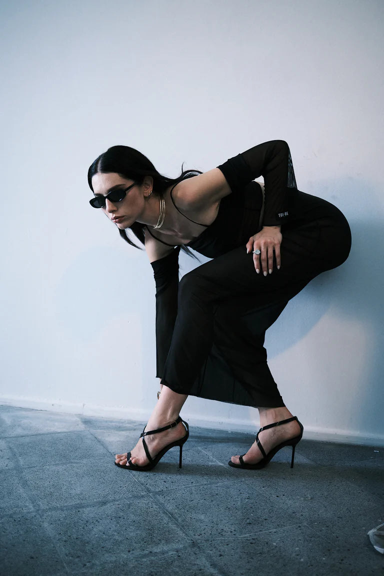 Woman in black outfit with high heels