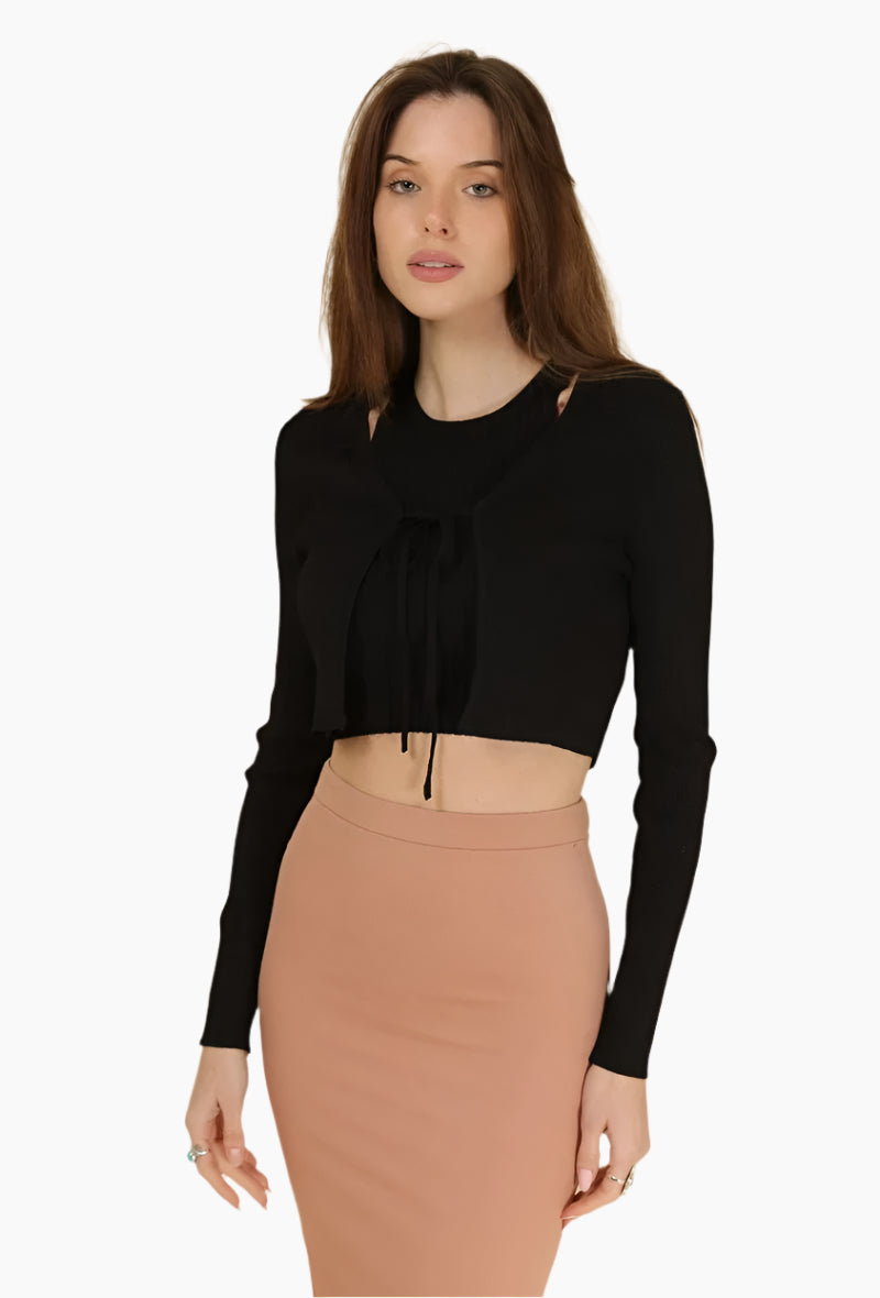 Woman wearing a black long-sleeve top and beige skirt
