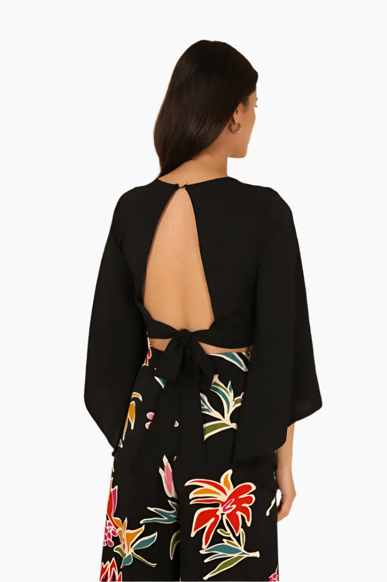 Woman wearing a black open-back top with colorful floral skirt