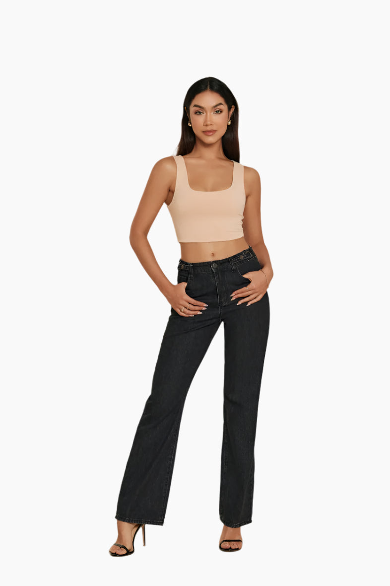 Woman wearing a beige crop top and black jeans