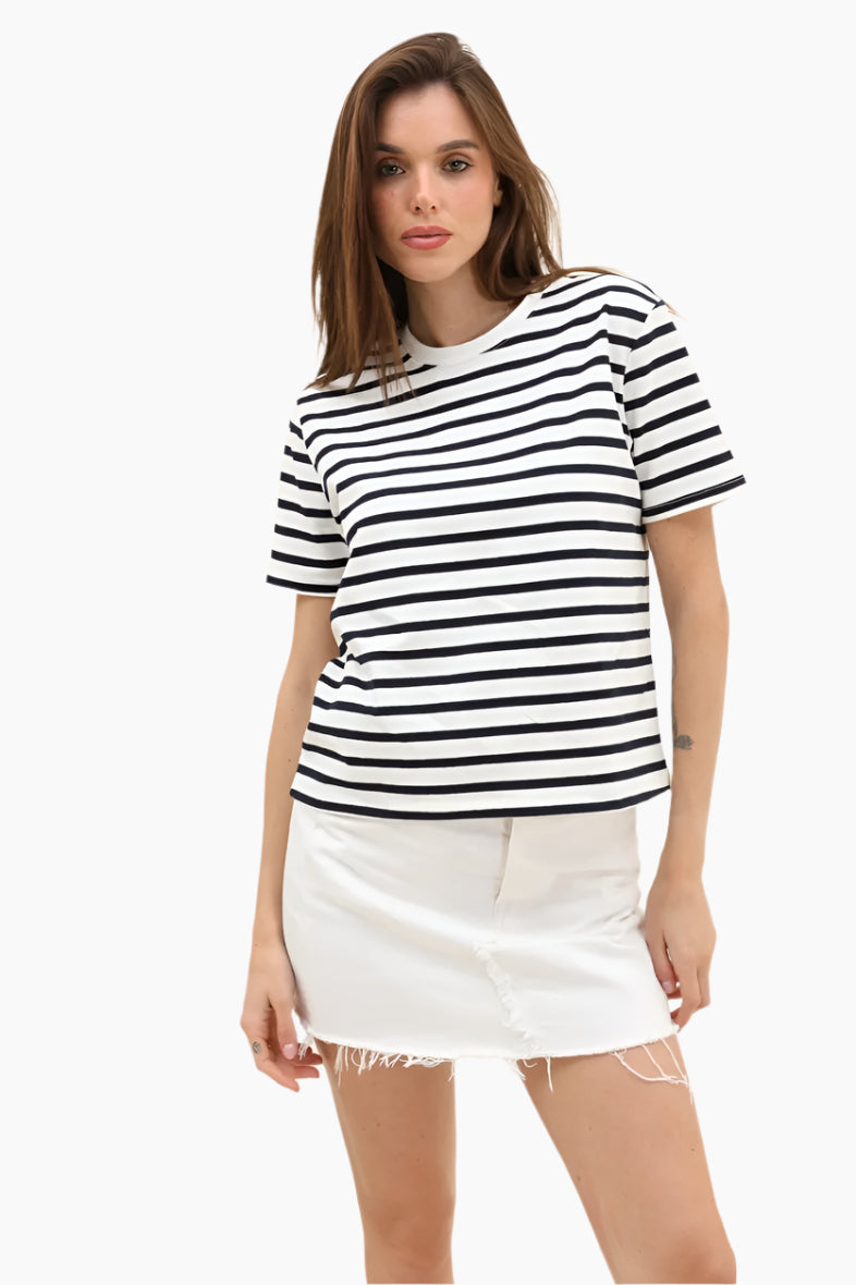 Woman wearing a black and white striped t-shirt and white skirt =