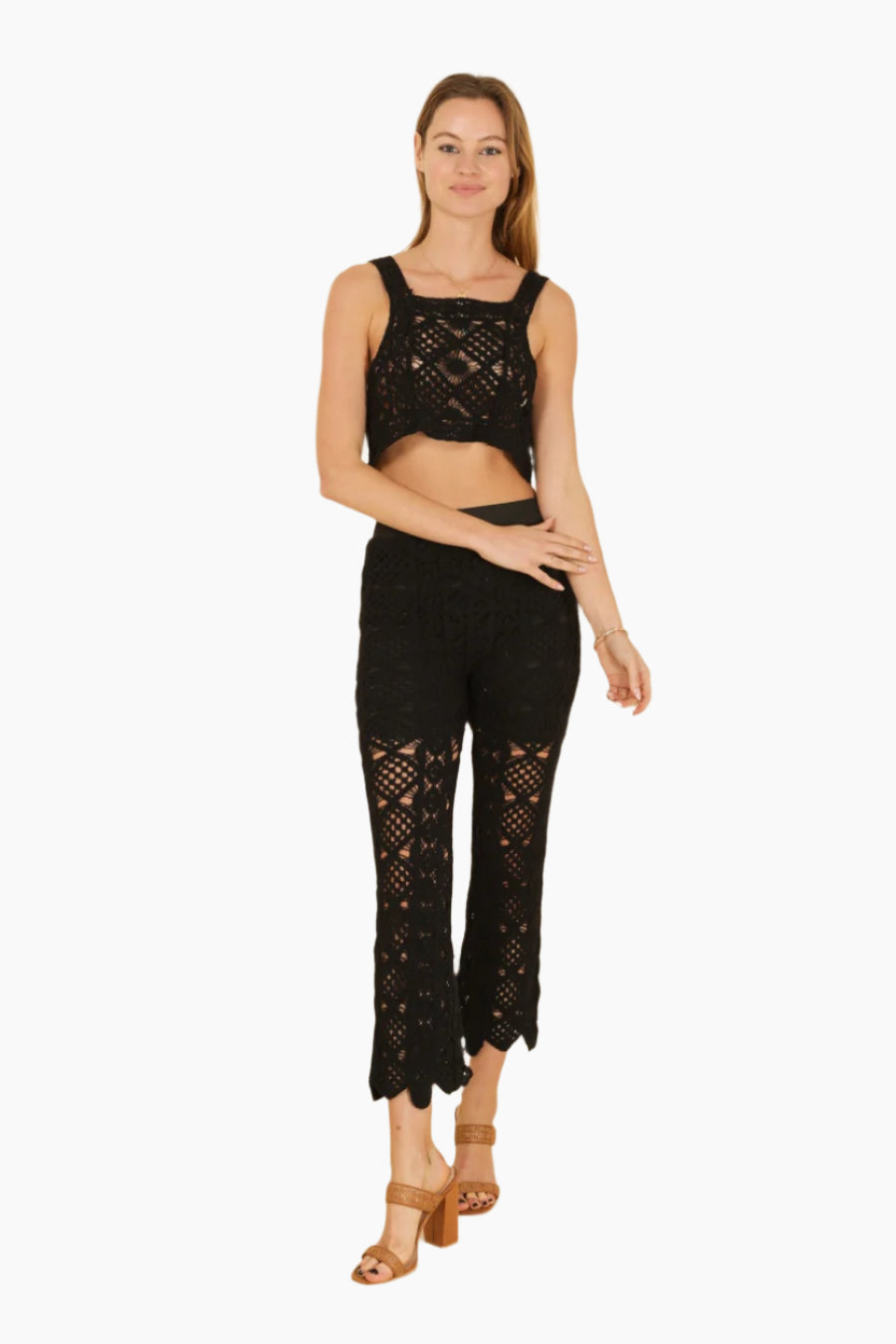Woman wearing a black lace outfit , black pants , black crop top , crochet