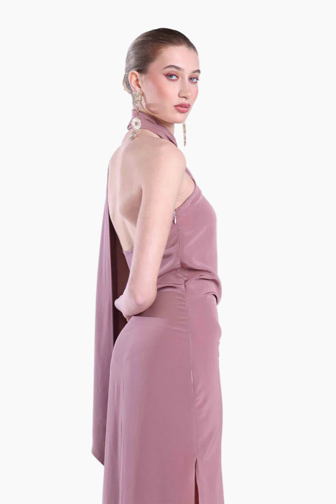 Woman wearing a mauve evening gown with a slit on a white background