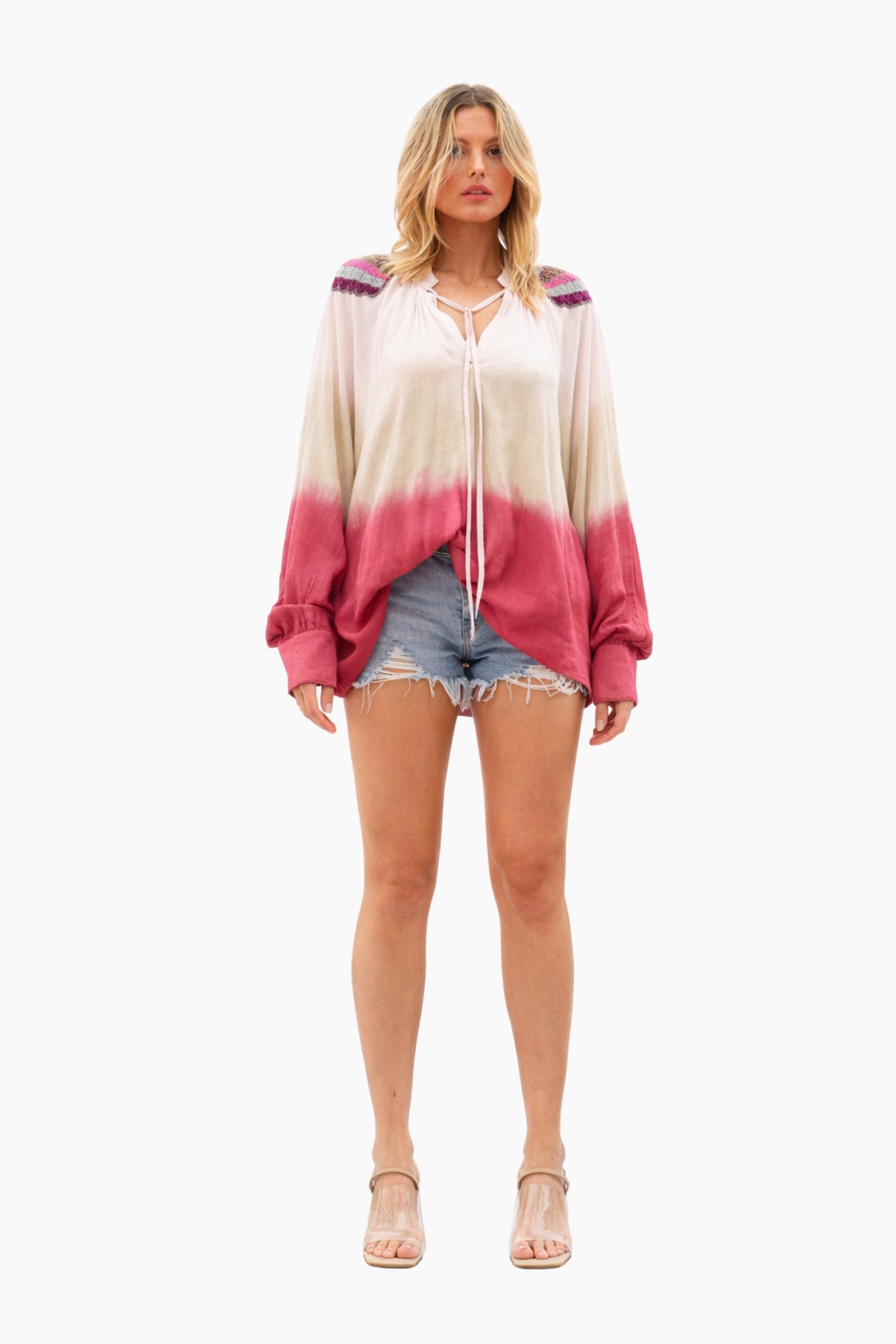 Woman wearing a colorful hoodie and denim shorts on a white background