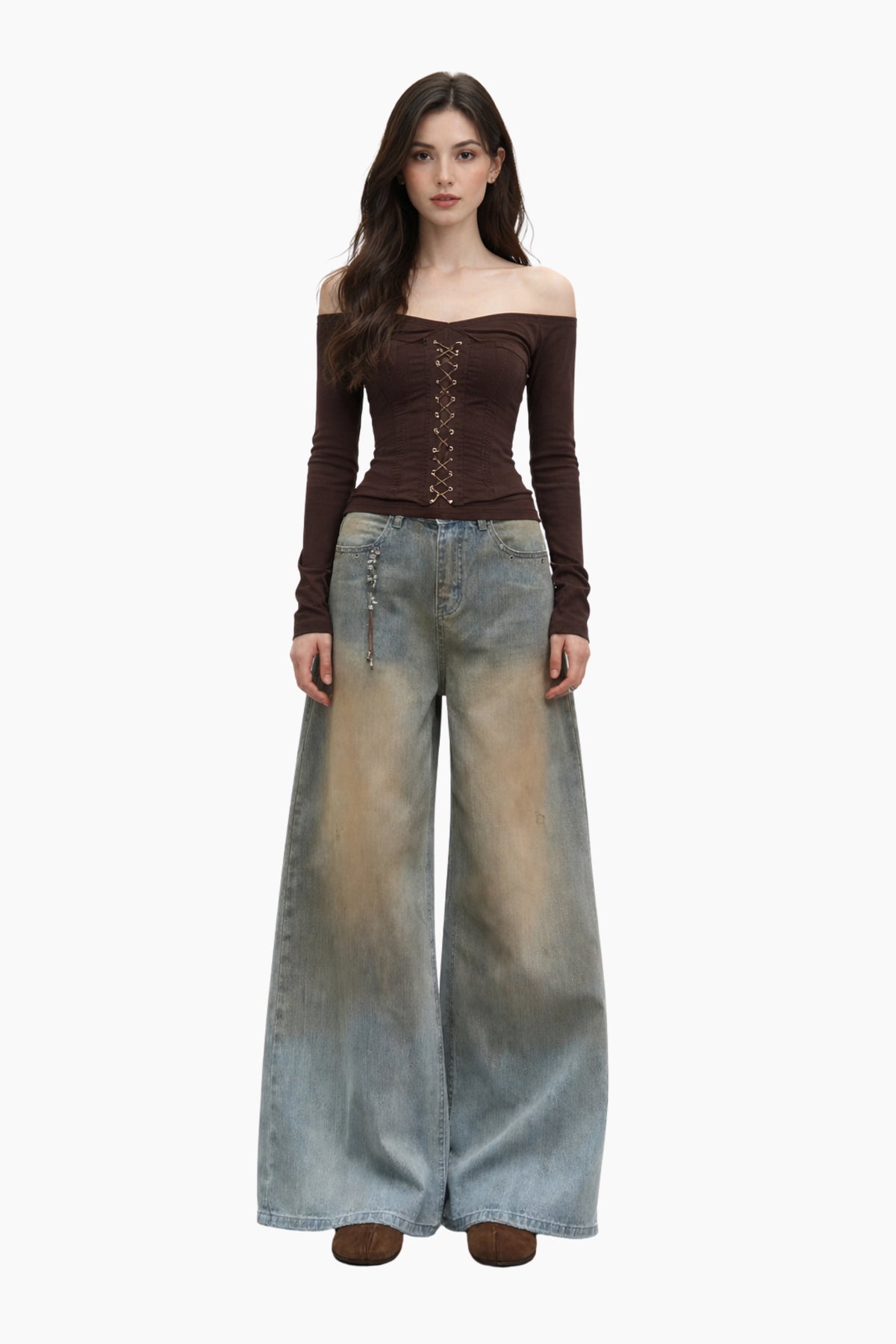 Woman wearing a brown off-shoulder top and wide-leg jeans on a white background