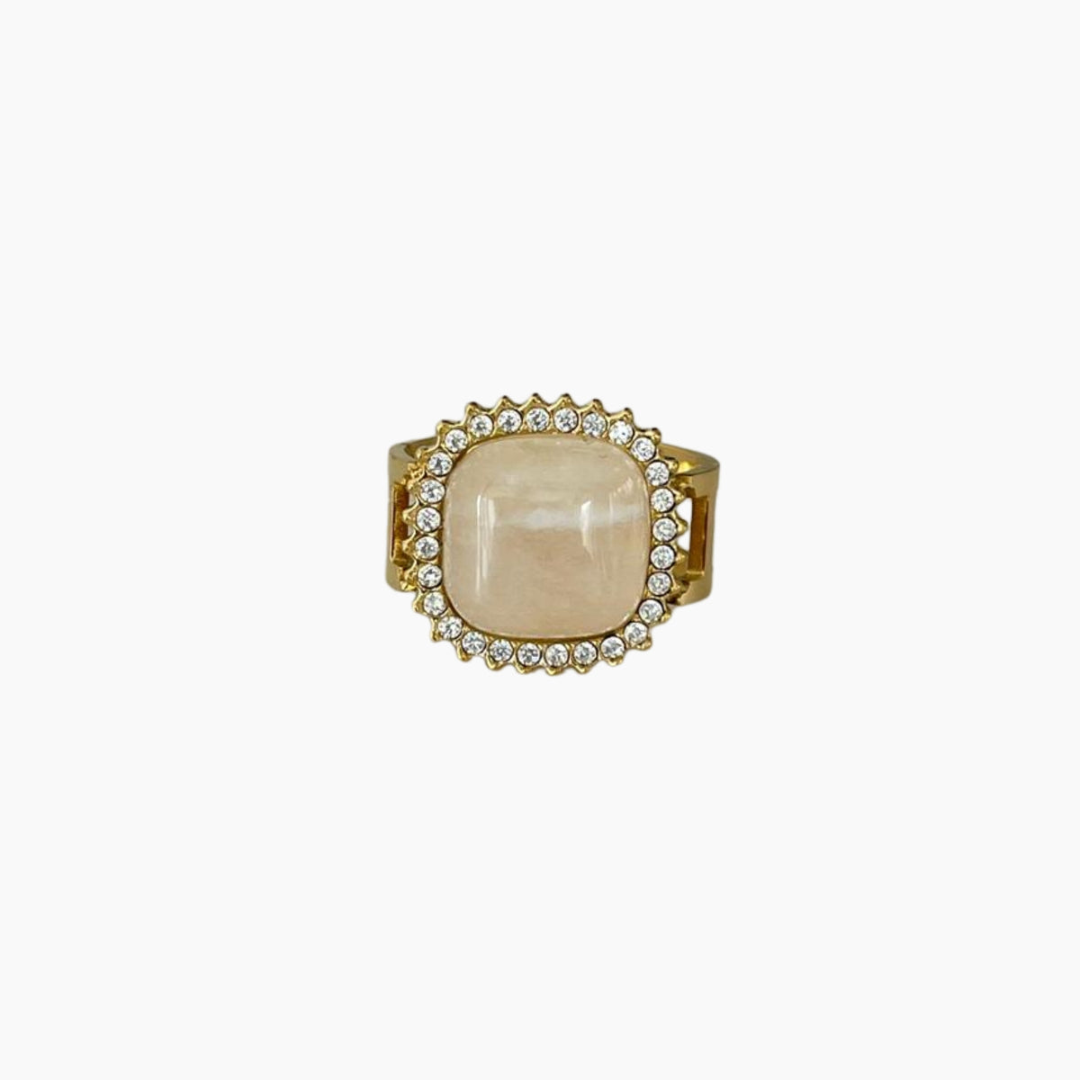 Gold ring with a large beige stone and smaller stones on a white background