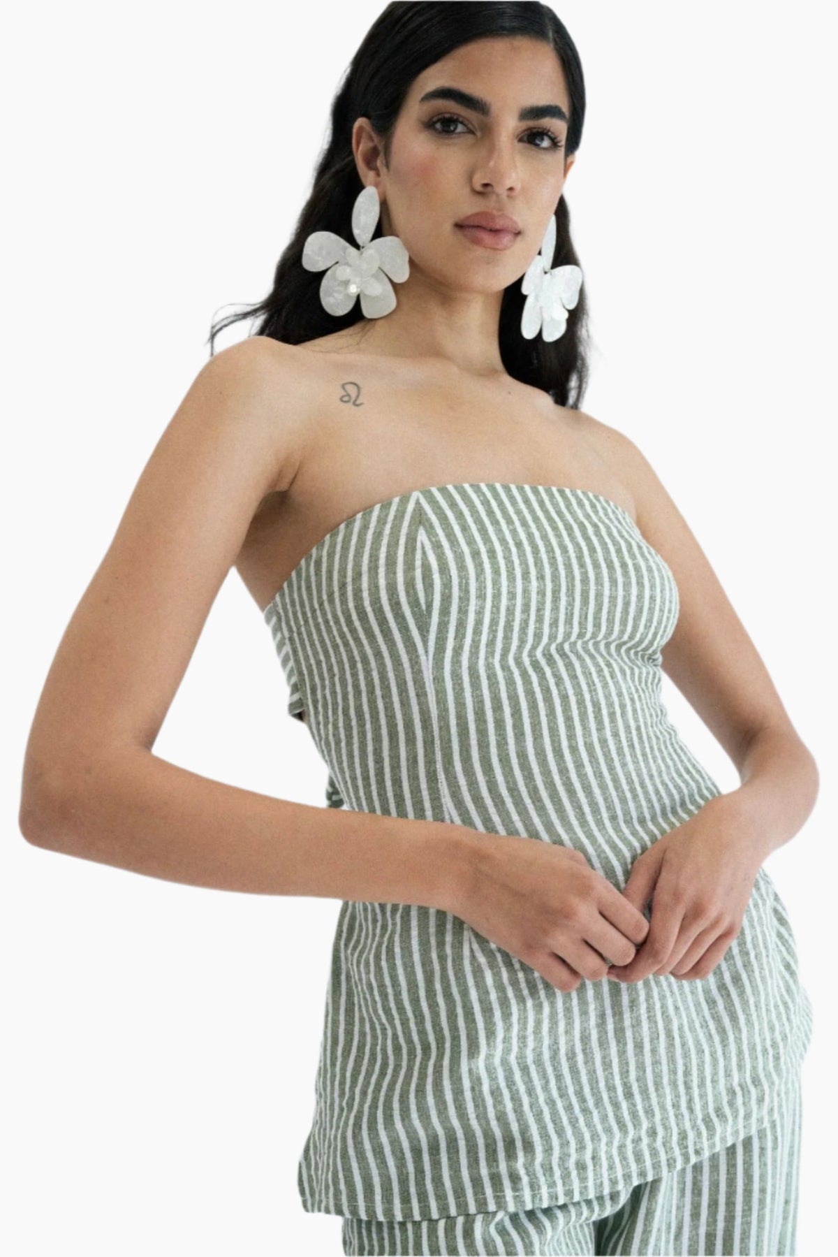Woman wearing a green and white striped strapless top and pants.