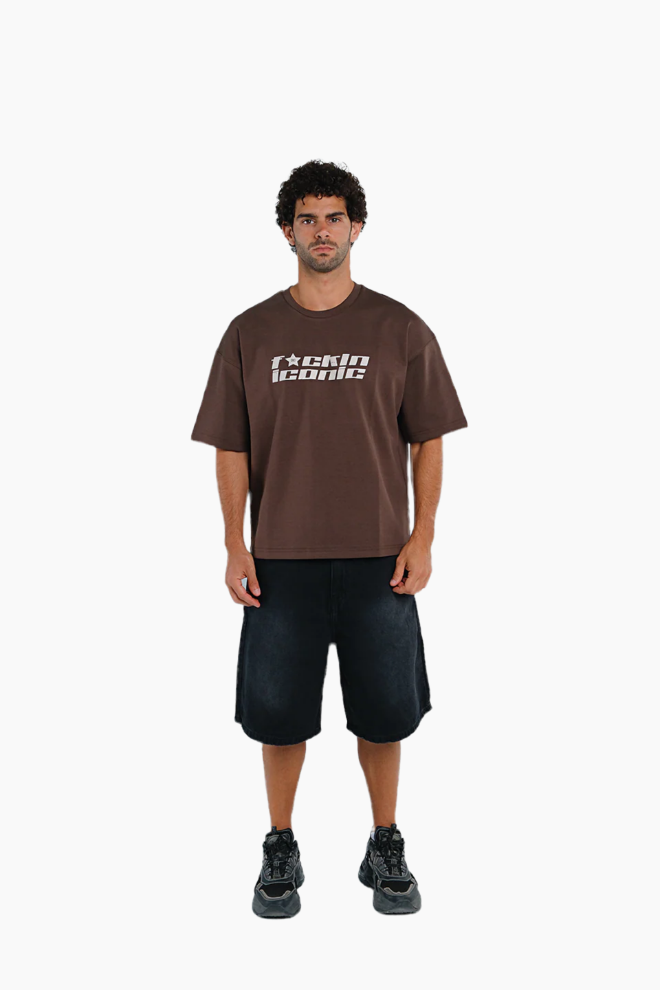 Man wearing a brown t-shirt with text and black shorts