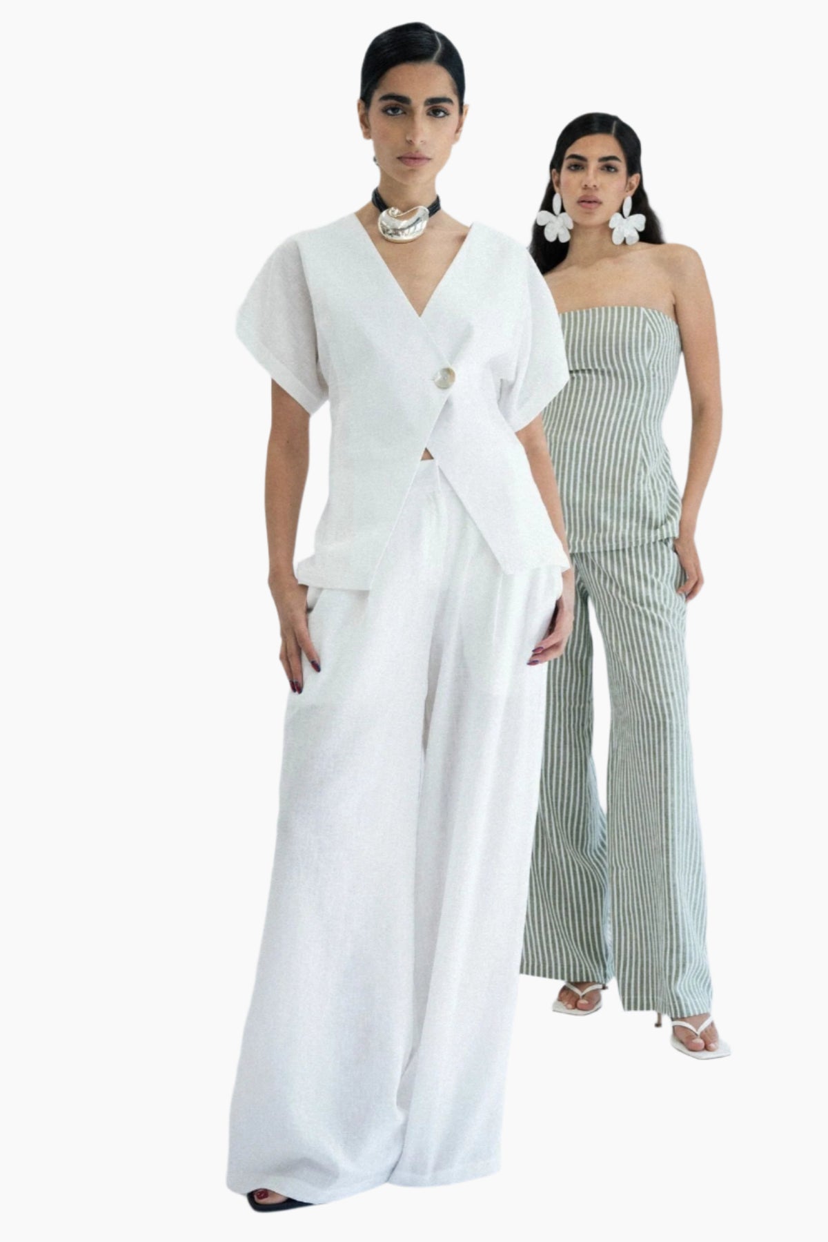 Two women in stylish outfits standing , pants High-rise waistline.