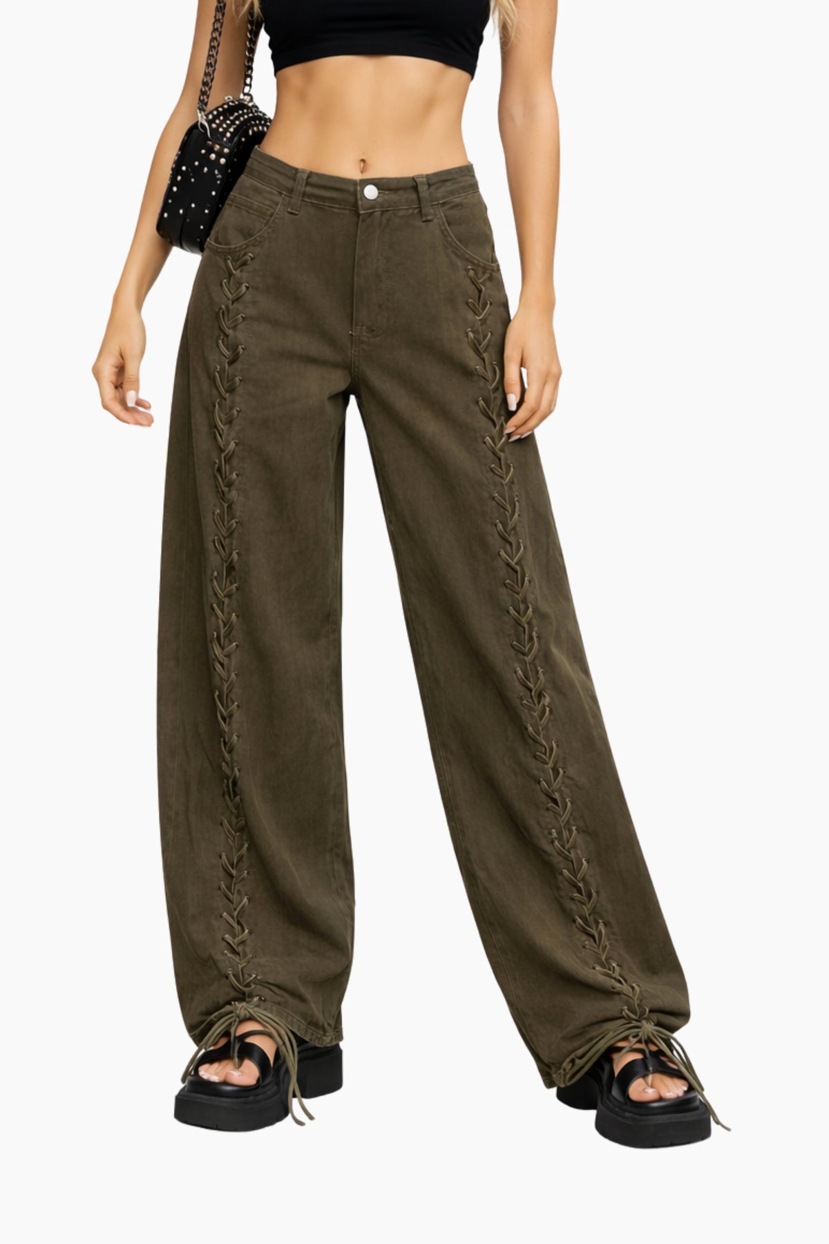 Person wearing olive green pants with lace-up sides on a white background