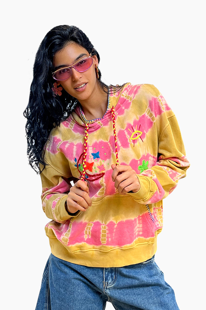 Person wearing a colorful tie-dye sweatshirt with pink and yellow patterns