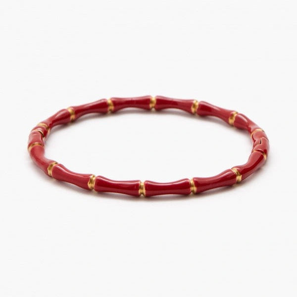 Red bracelet with gold accents on a white background