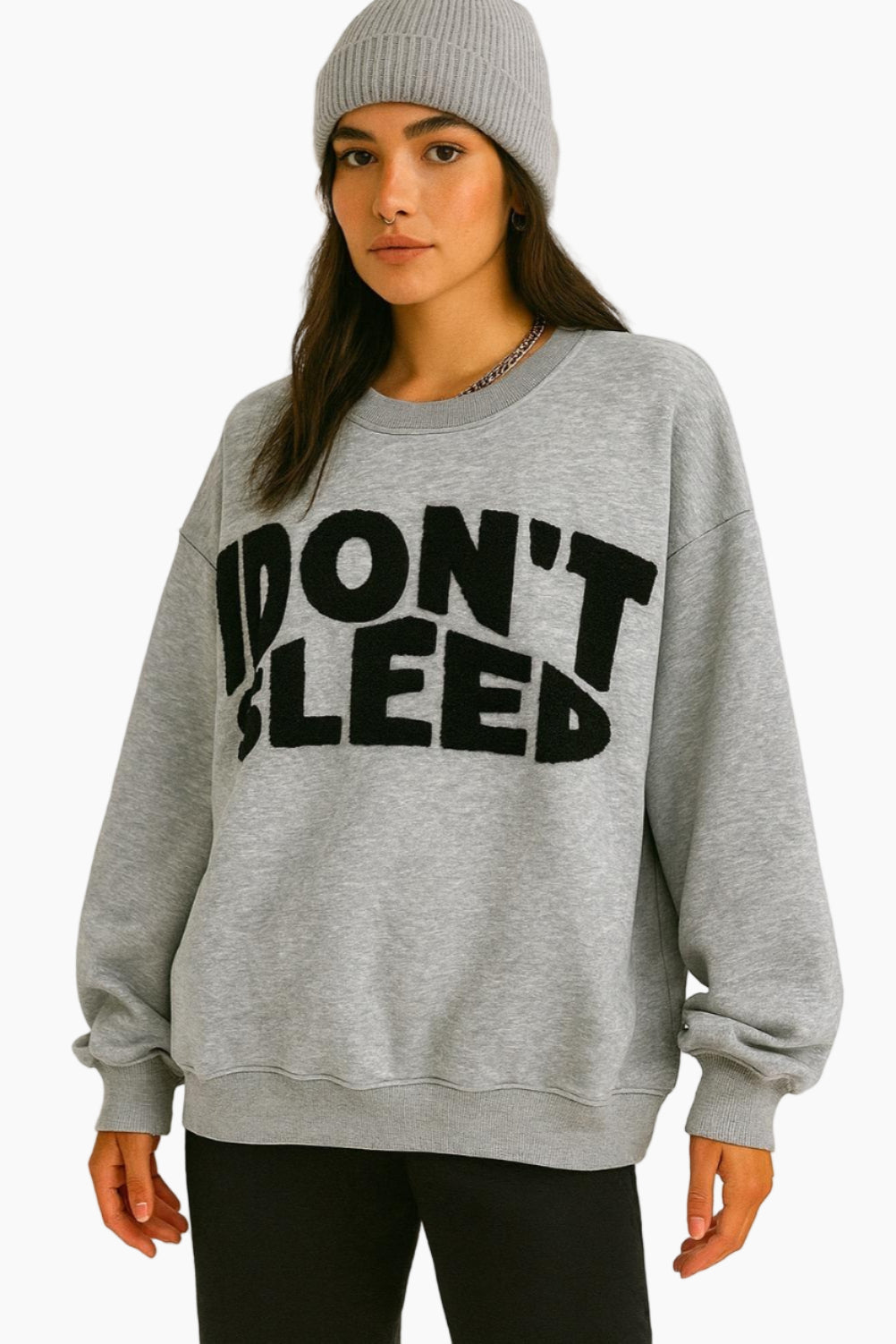 Person wearing a gray sweatshirt with 'IDON'T SLEEP' text on a white background