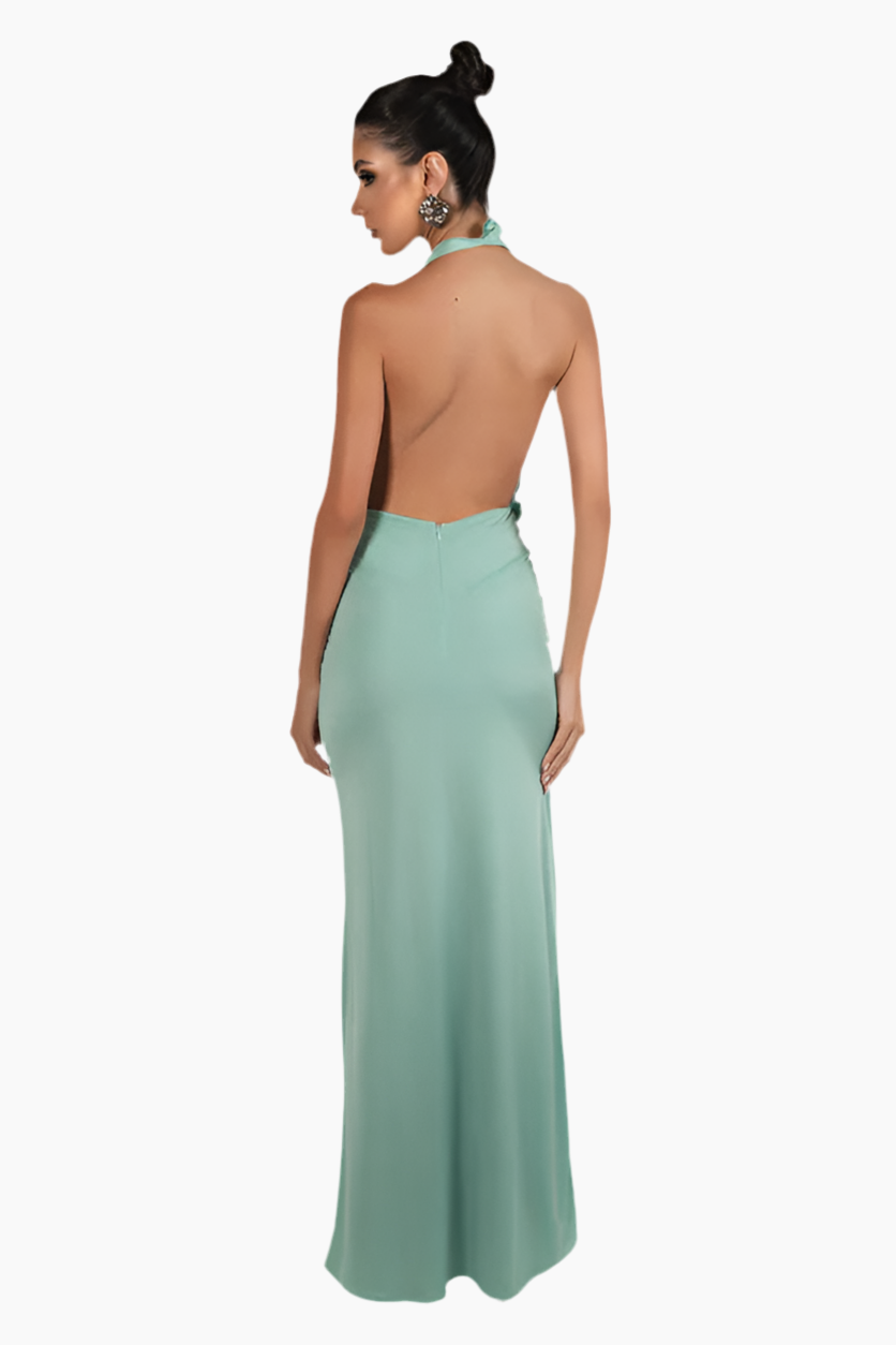 Woman wearing a light green evening gown with an open back.