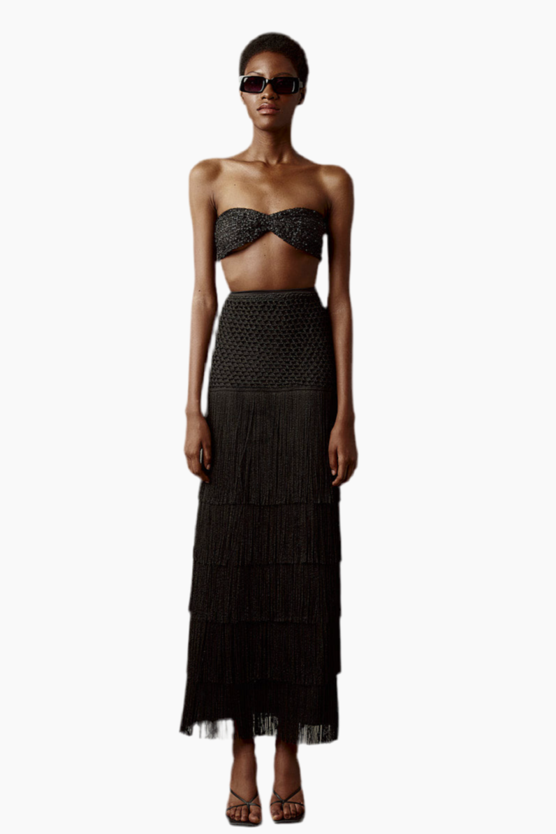 Woman wearing a black strapless top and tiered skirt with sunglasses