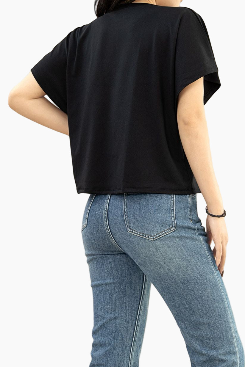 Person wearing a black t-shirt and blue jeans