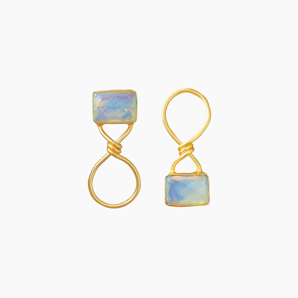 Gold earrings with square gemstones on a white background