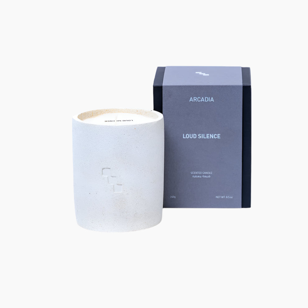 Candle and its packaging labeled 'Arcadia Loud Silence' . VANILLA, CEDARWOOD