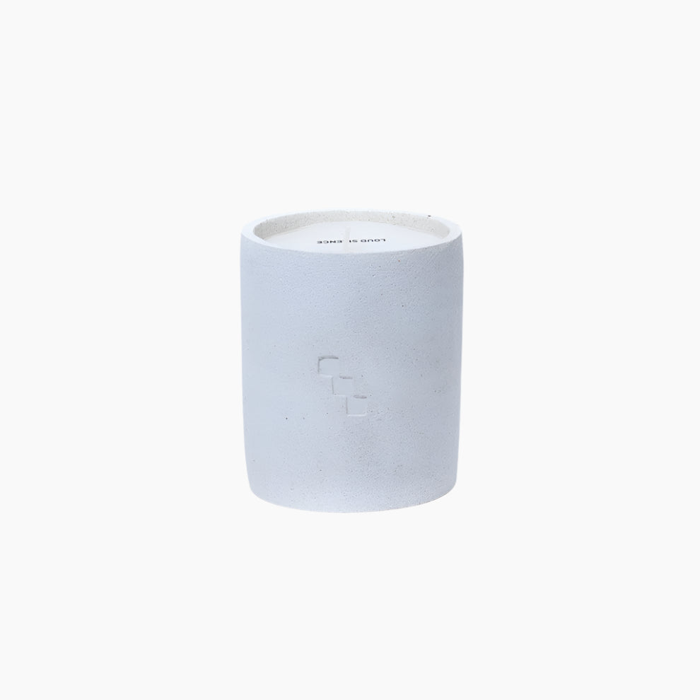 Candle and its packaging labeled 'Arcadia Loud Silence' . VANILLA, CEDARWOOD