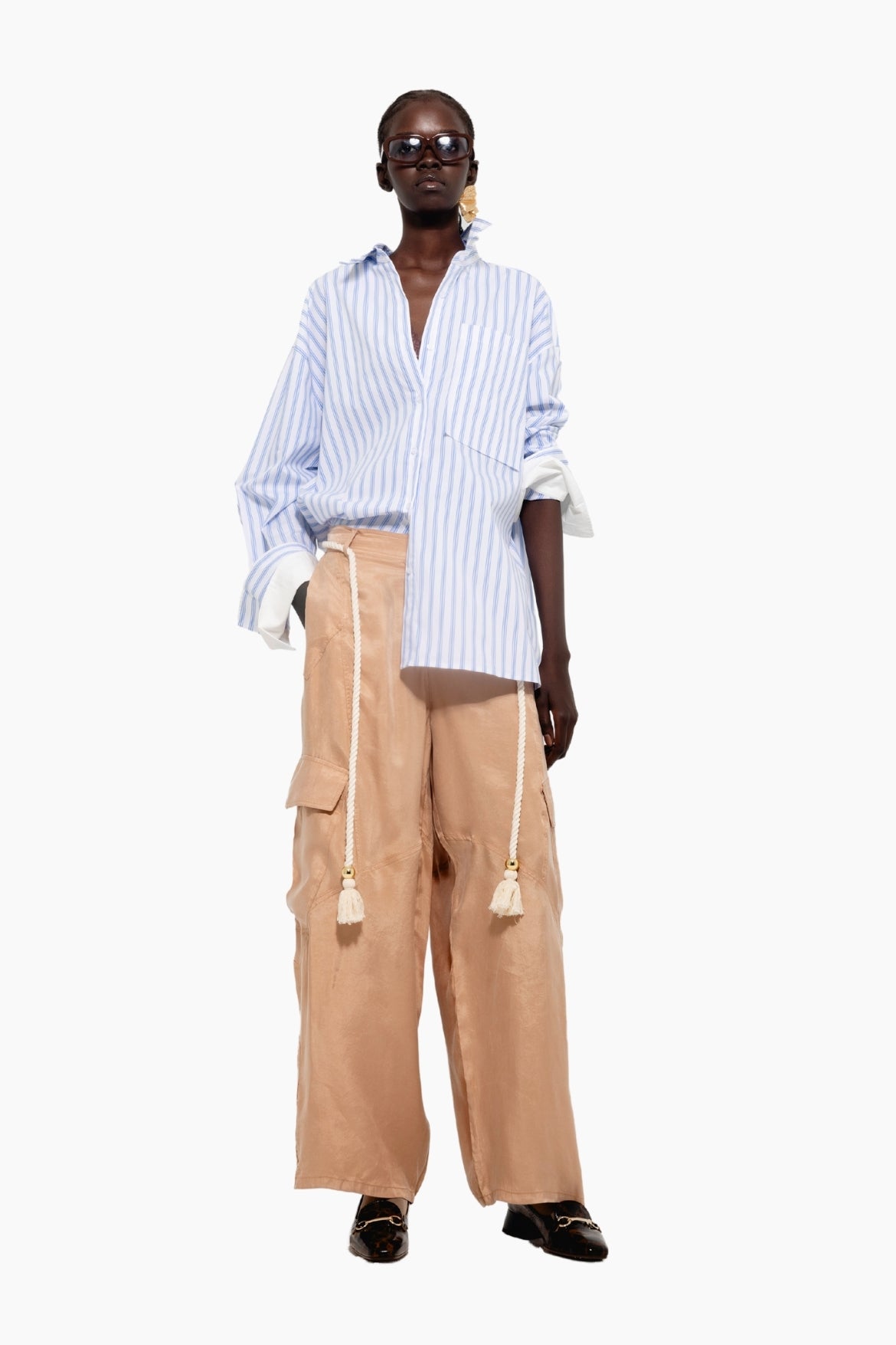 Person wearing a striped shirt and beige pants