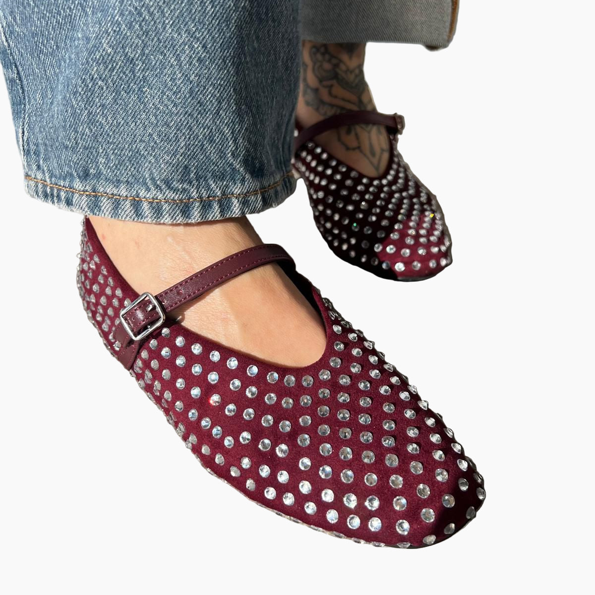 Maroon studded shoes worn with blue jeans
