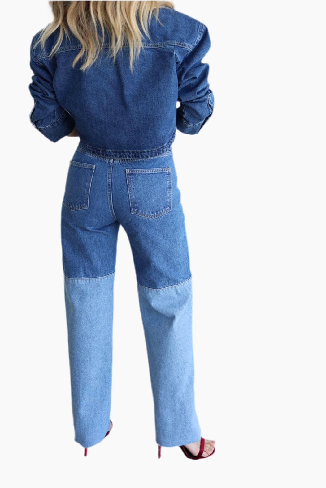 Person wearing a blue denim jumpsuit on a white background