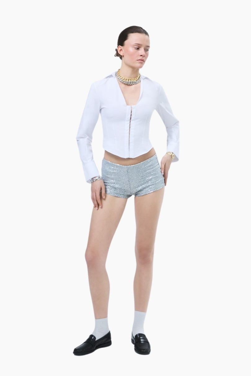 Woman wearing a white long-sleeve shirt and shorts