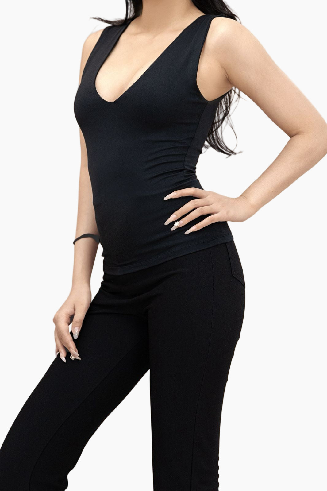 Person wearing a black sleeveless top and pants on a white background