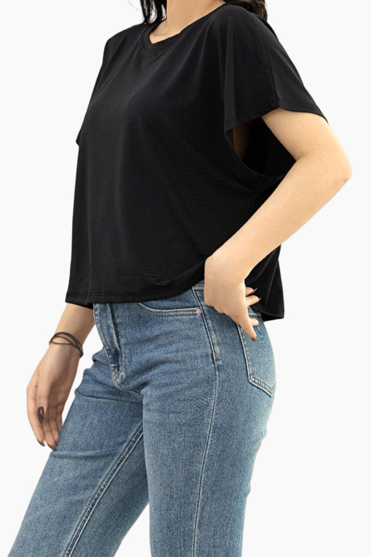 Person wearing a black t-shirt and blue jeans