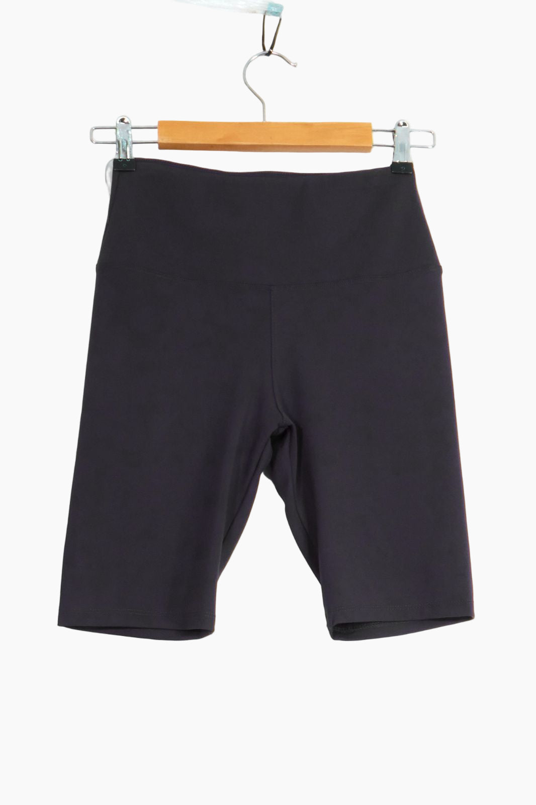 Black shorts hanging on a wooden hanger