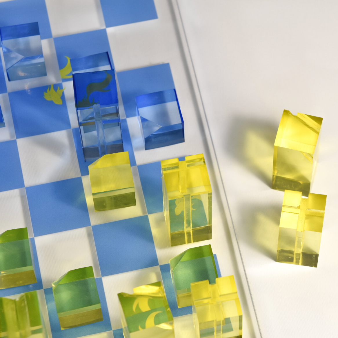 Close-up of a checkered pattern with blue, green, and yellow squares on a white background.