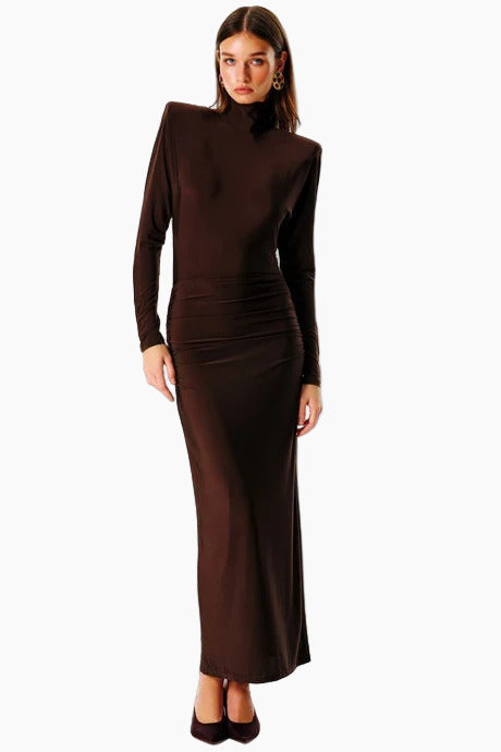 A model wearing a brown backless maxi dress with three-quarter sleeves and a V-neck neckline.