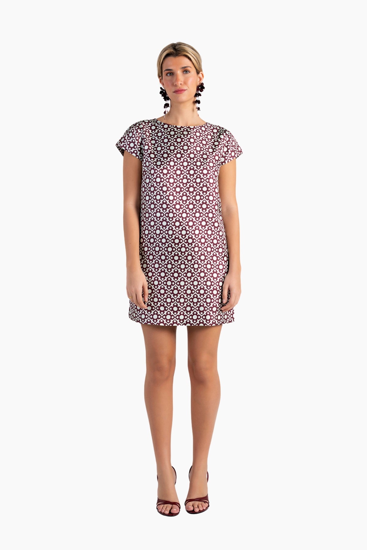 Woman wearing a patterned dress on a white background