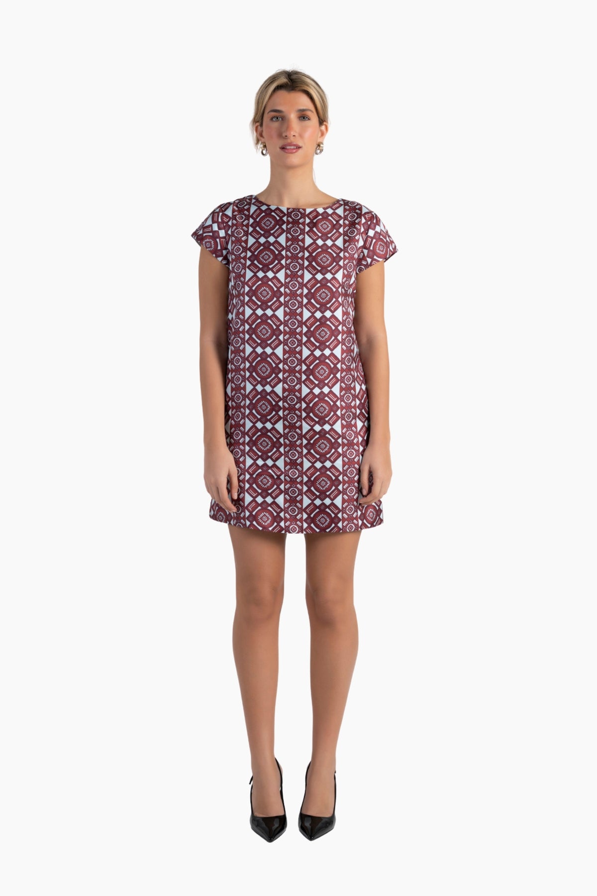 Woman wearing a patterned dress on a white background