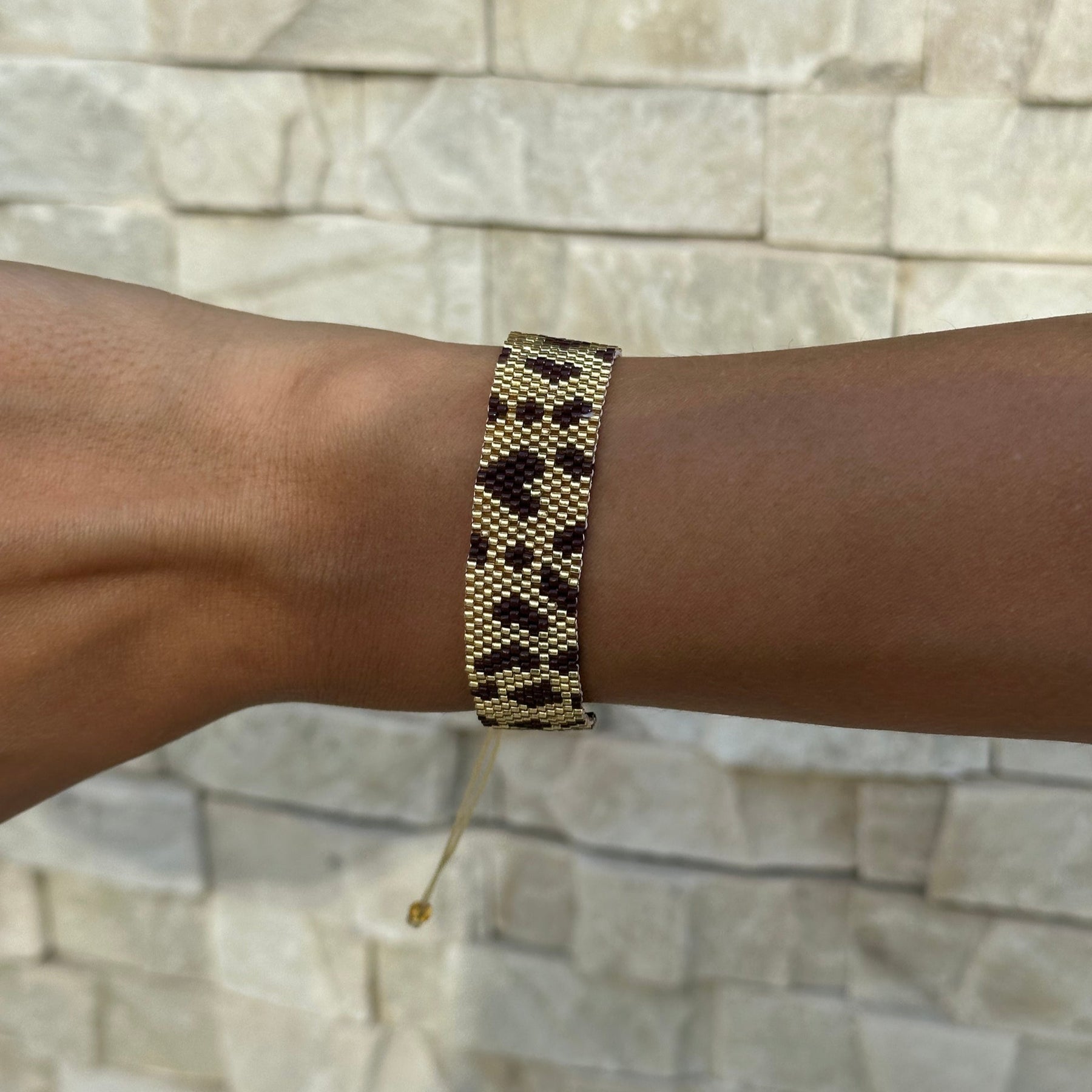 Bracelet on a wrist with a stone wall background