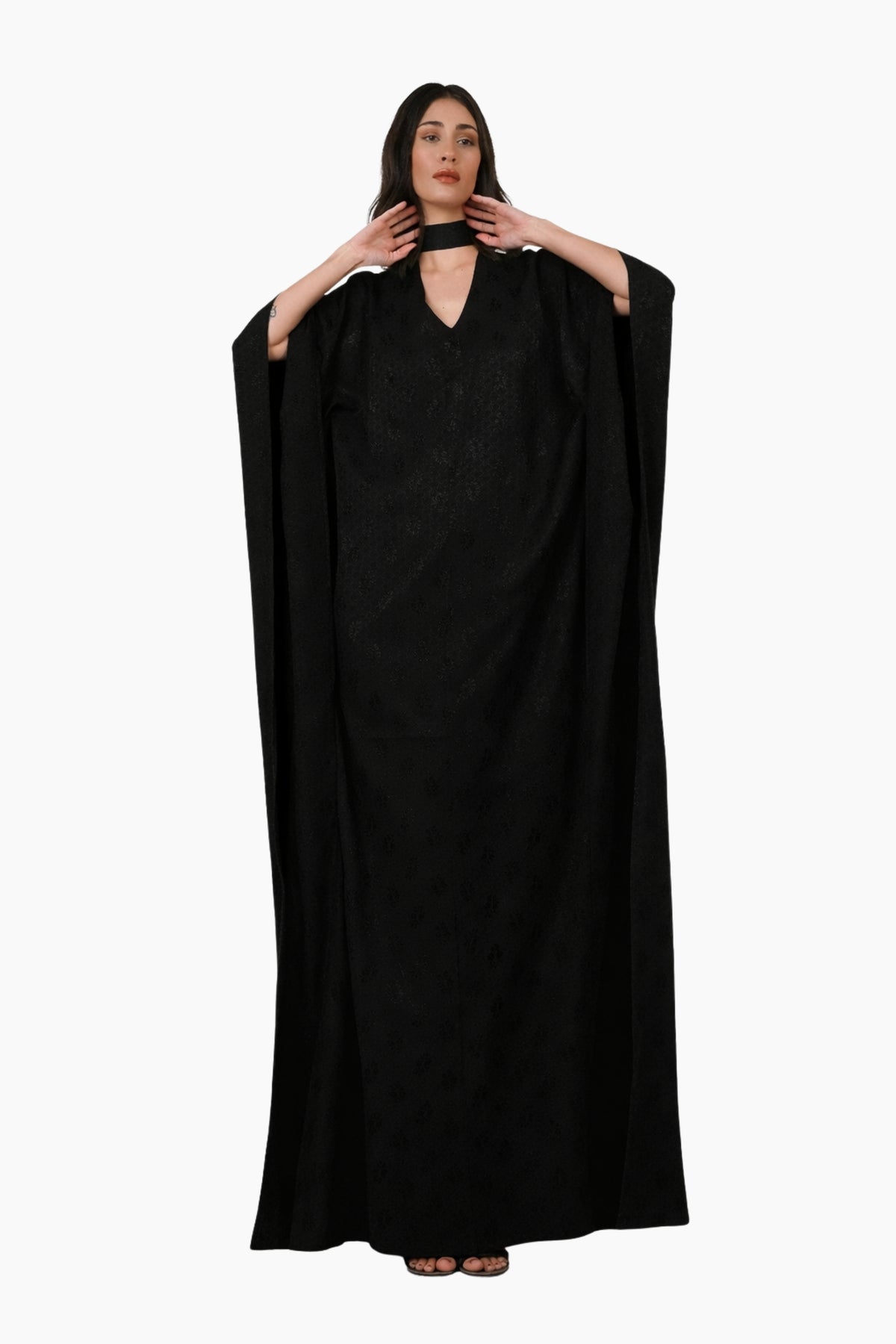Woman wearing a black abaya on a white background