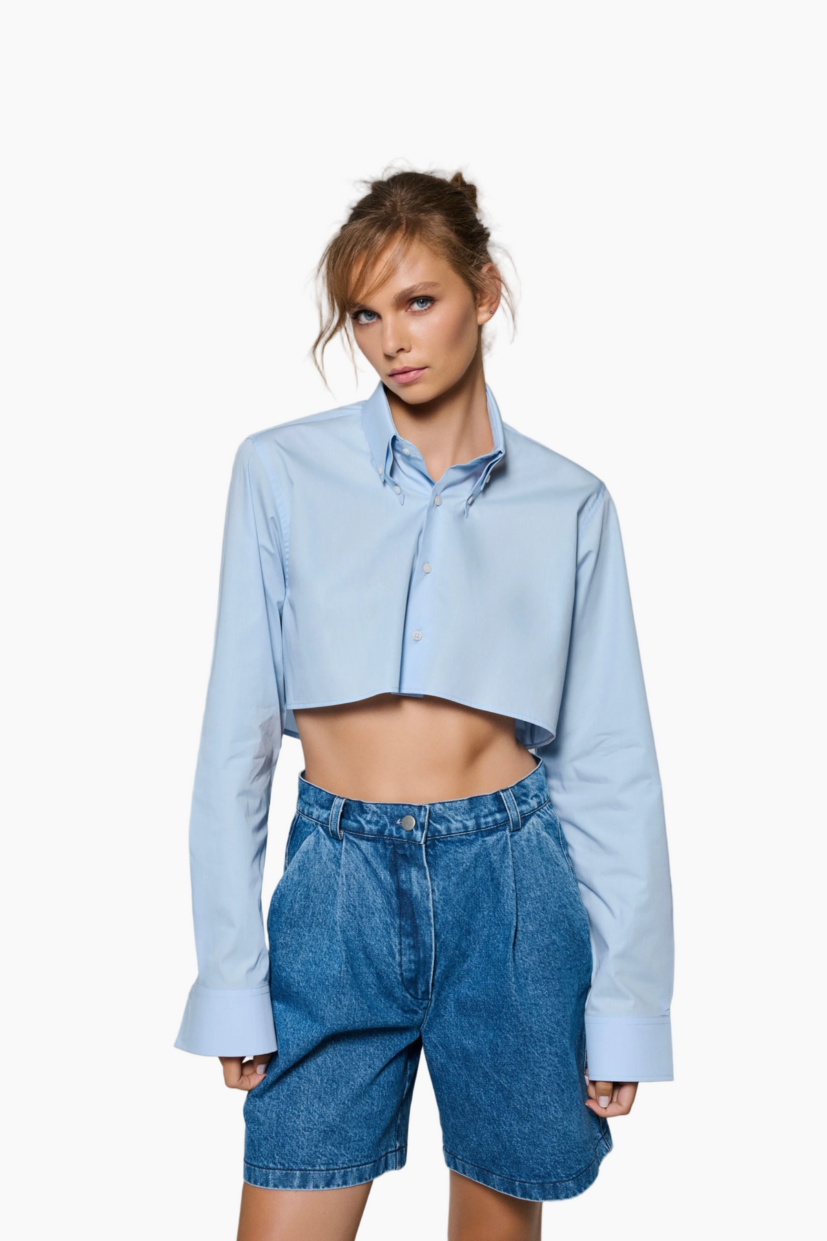 Woman wearing a Waist cropped Long Sleeve shirt made of fine Poplin fabric. Enhanced with a double-collar detail.