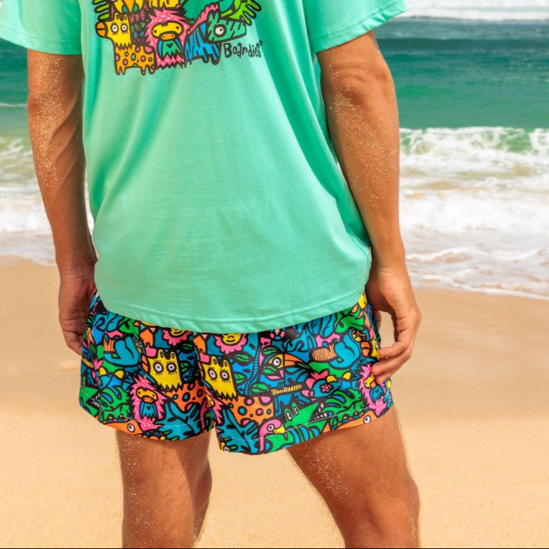 Man wearing a bright green t-shirt and colorful shorts standing