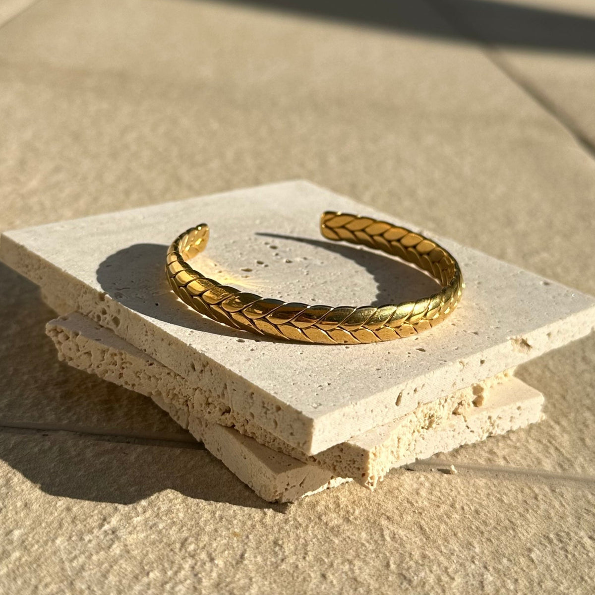 Gold bracelet on a textured stone surface