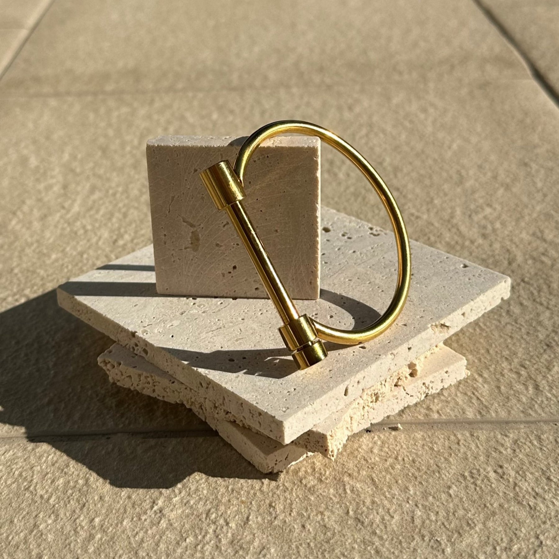 Gold ring on a stone surface with a neutral background