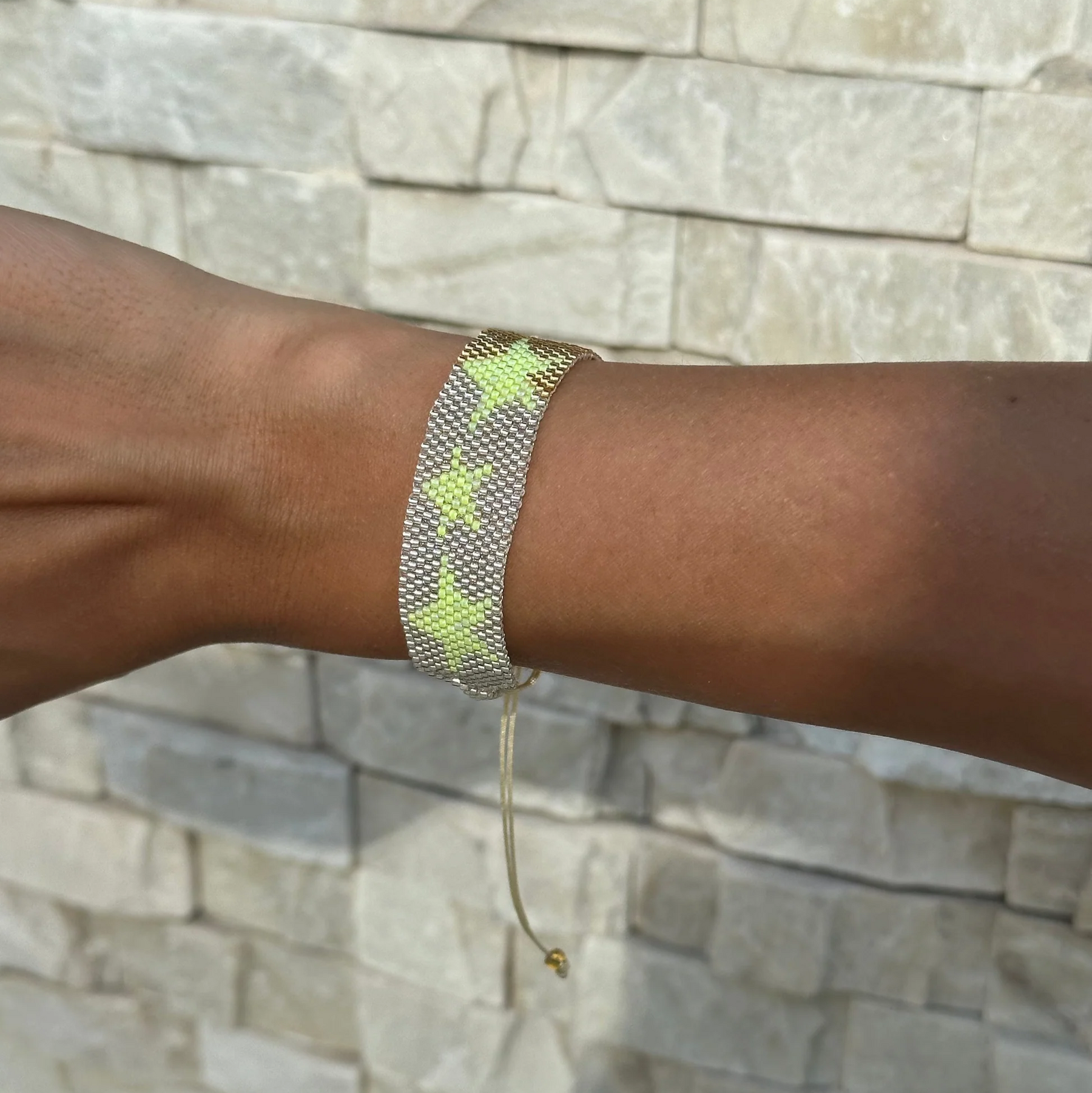 Bracelet on a wrist with a stone wall background