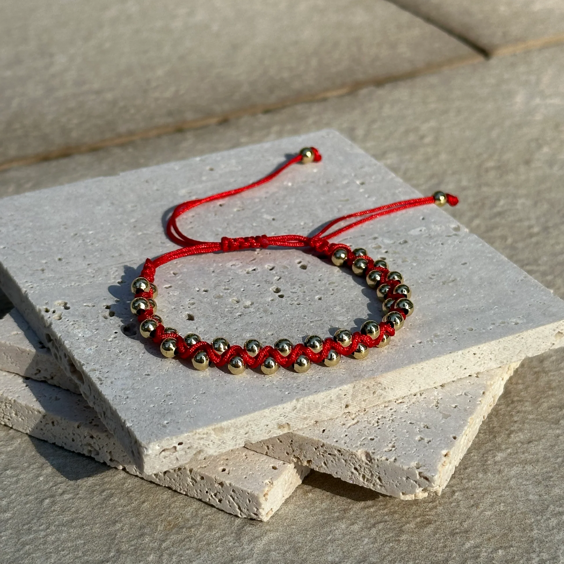 Red beaded bracelet on a concrete surface