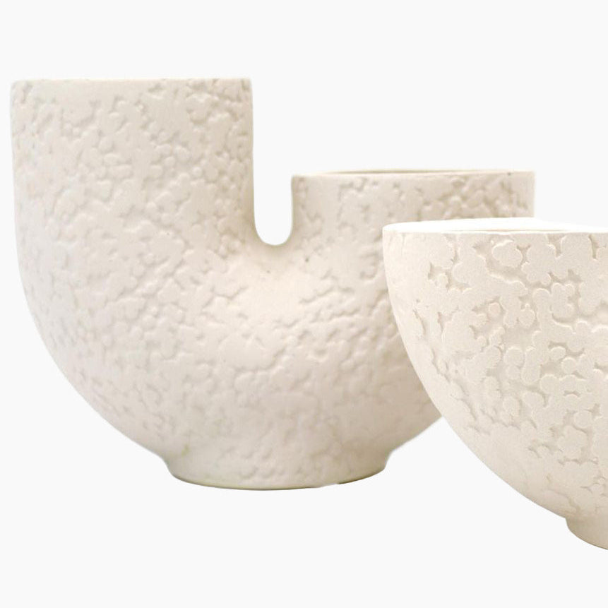 Two textured white ceramic bowls on a white background