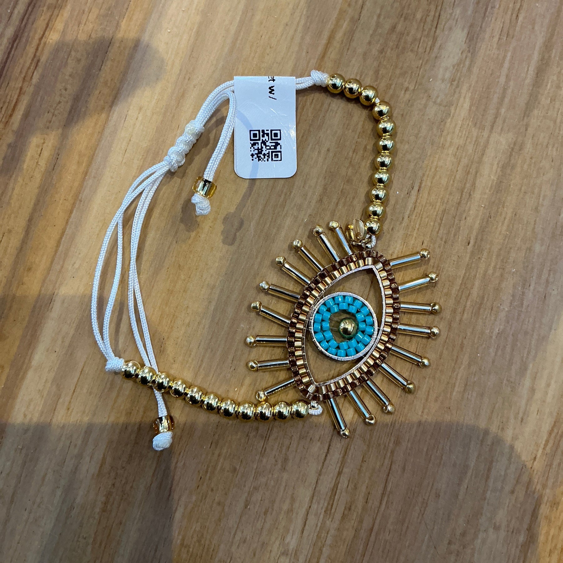 Decorative headband with eye design on a wooden surface