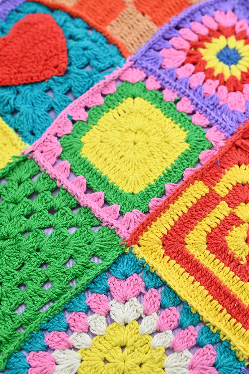 A multicolored crochet tote bag with a playful, patchwork design featuring various geometric and heart-shaped patterns.