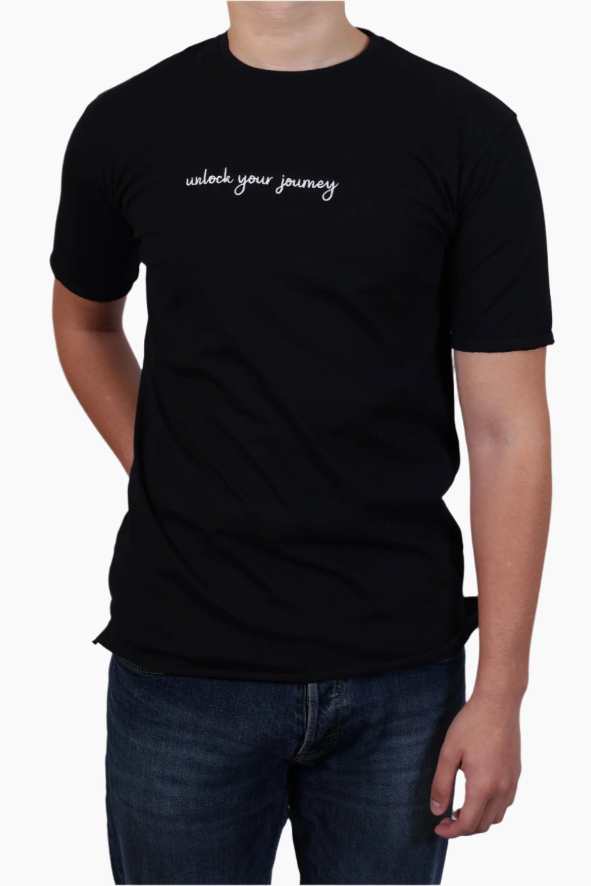 Person wearing a black t-shirt with 'unlock your journey' text , Unisex