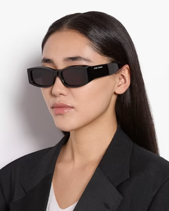 Woman wearing black sunglasses with a plain background