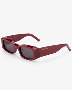 Red sunglasses with a gold logo on a white background